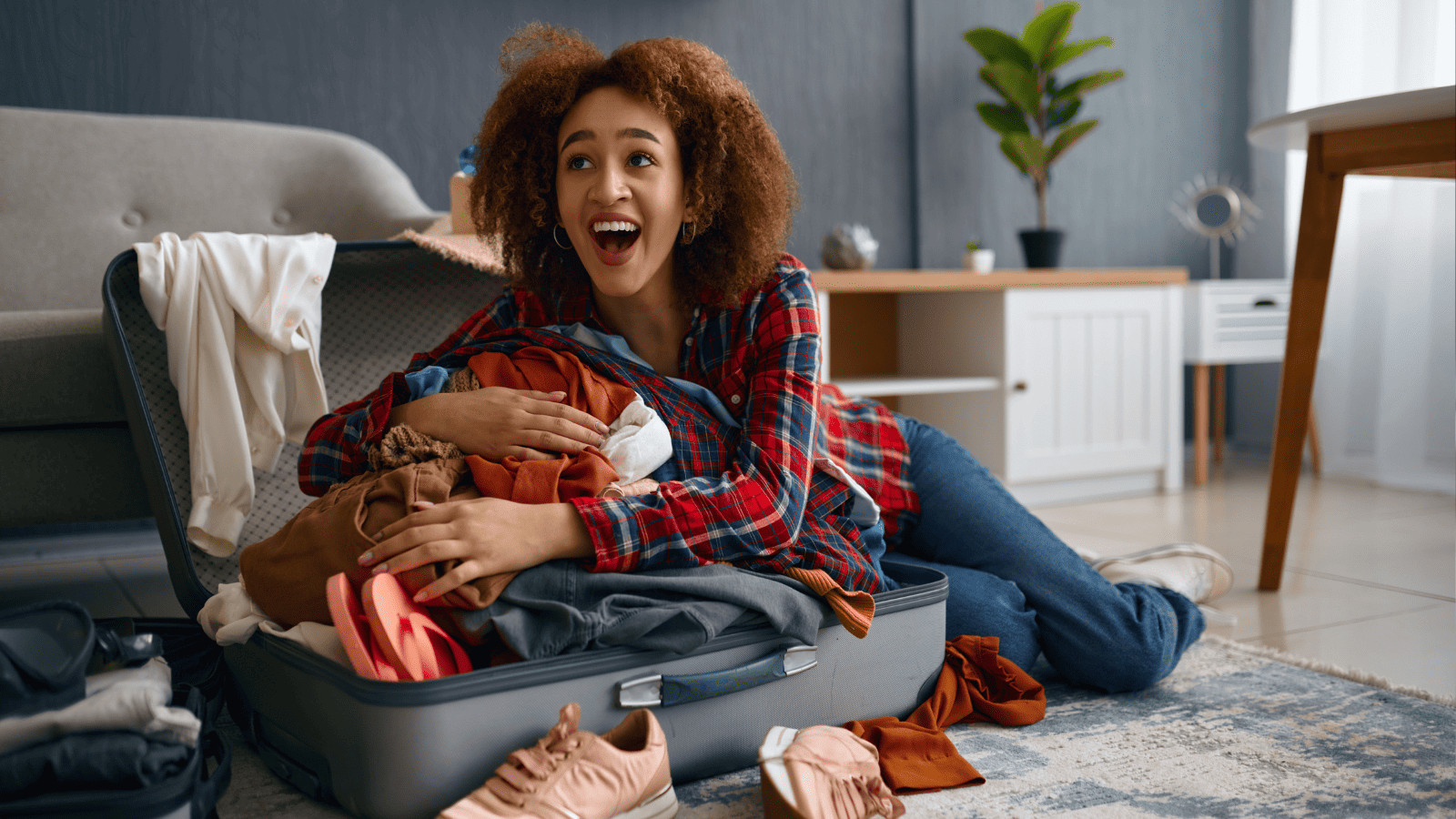 Uncover 11 Must-Have Summer Travel Accessories 10 Happy woman packing suitcase