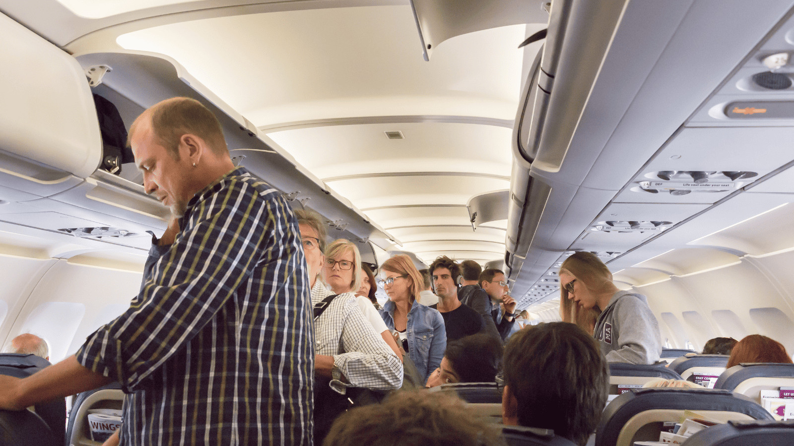 12 Cringeworthy Travel Habits That Make Everyone Secretly Hate You 5 Standing in Plane