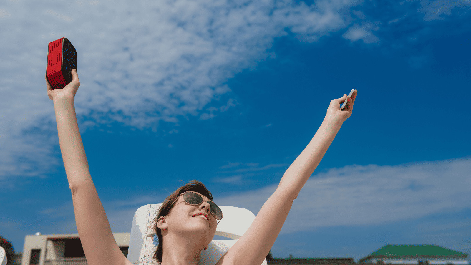 Uncover 11 Must-Have Summer Travel Accessories 7 Woman holding portable Bluetooth speaker