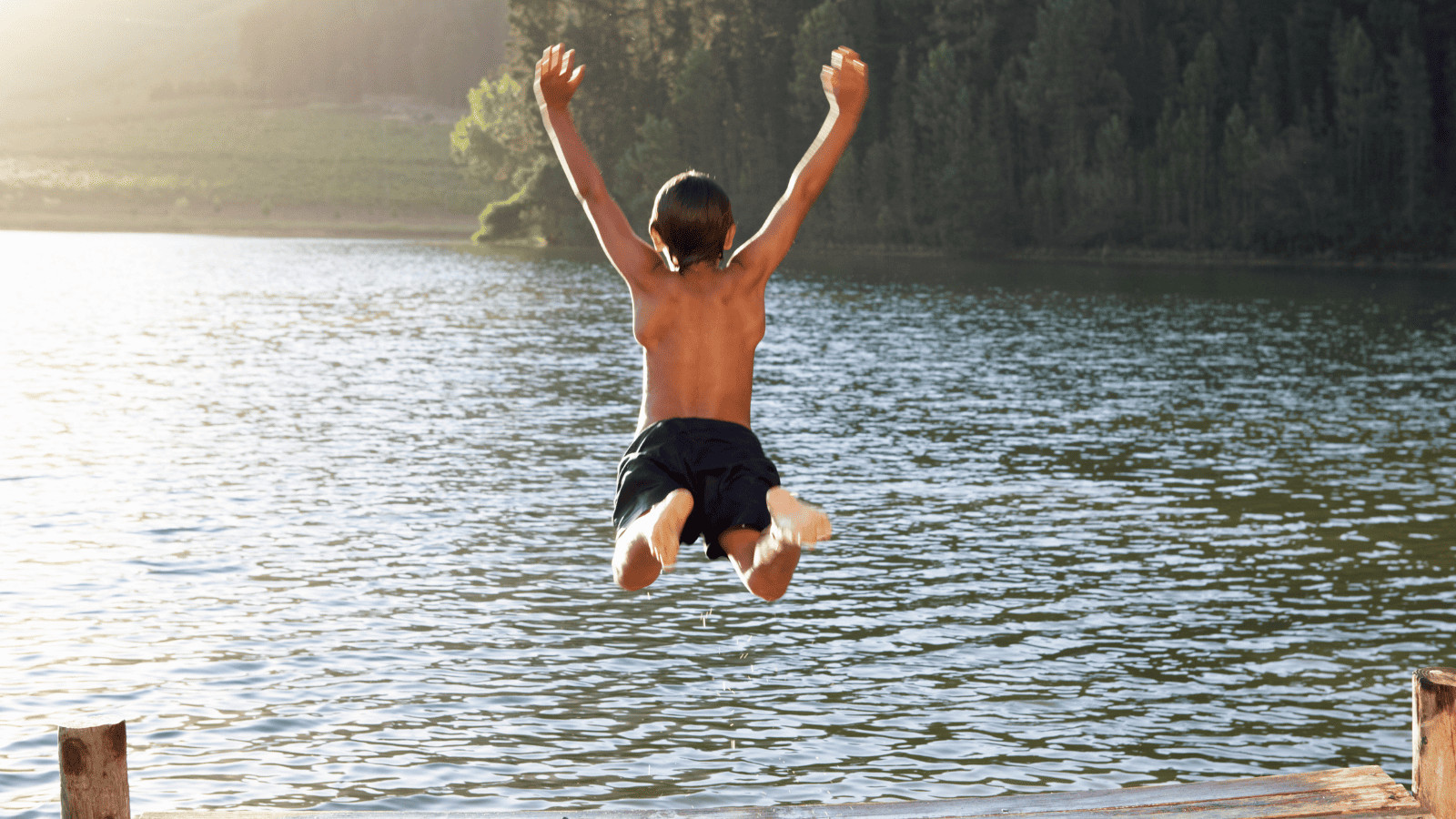Boy jumping into a lake