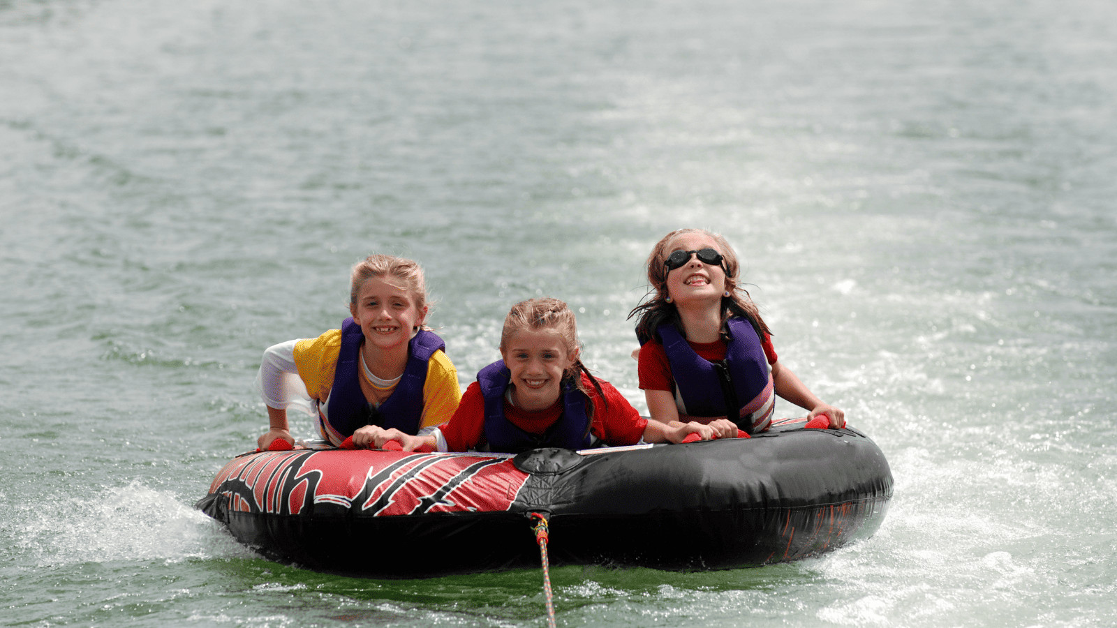 Three girls lake tubing