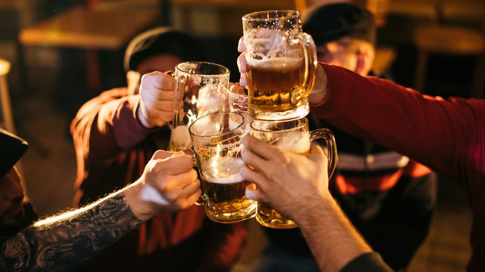 men clinking glasses of beer in a pub