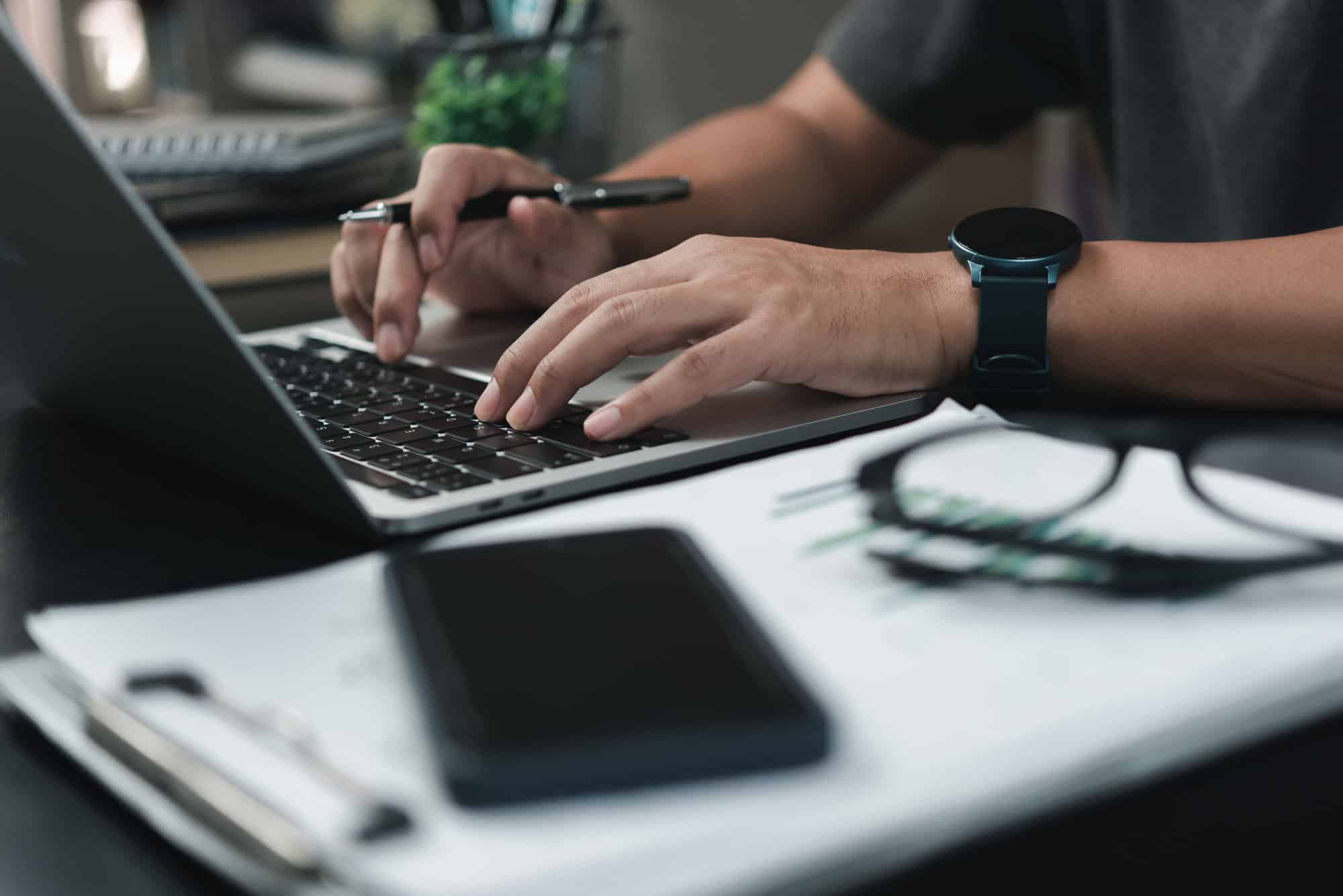 10 Things to Do Before You Leave for a Long Trip 1 Man using laptop at his workplace.business document strategy.