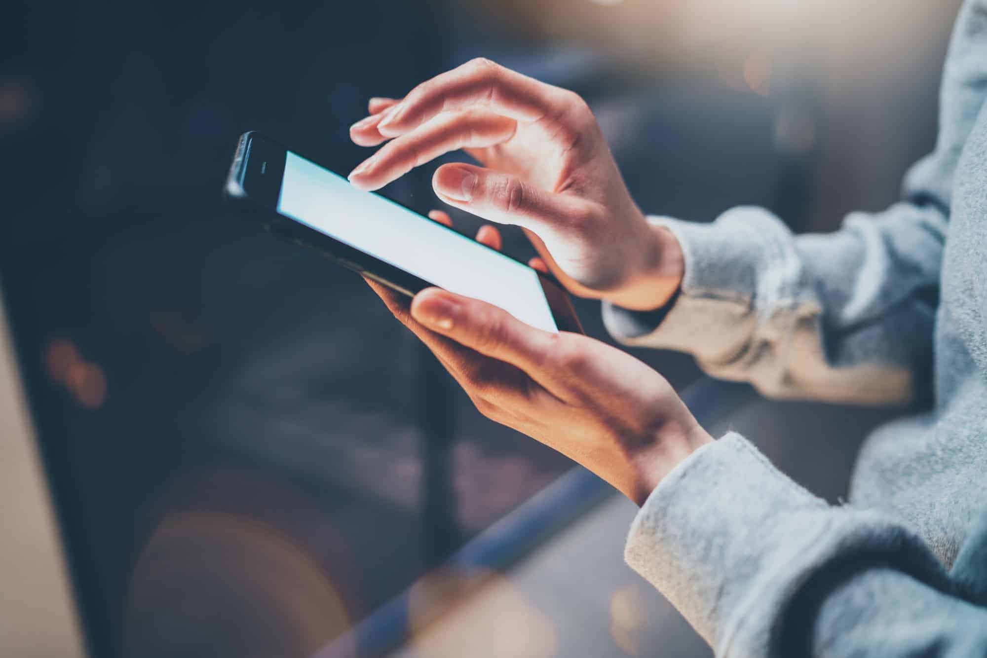 Female finger pointing on screen of phone