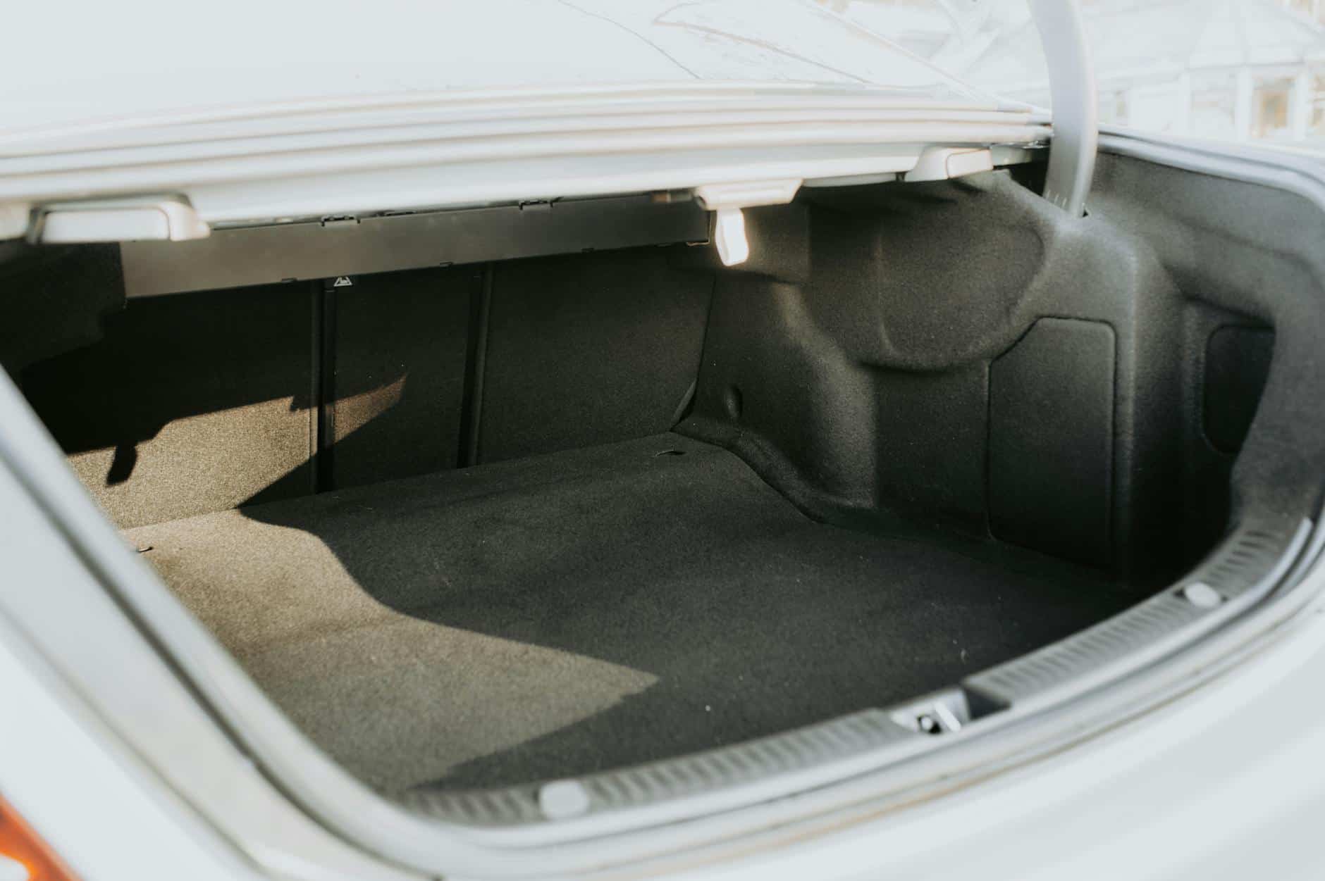 15 Road Trip Car Organizers for Traveling With Kids 10 An empty car trunk highlighted by bright sunlight, showing ample space.