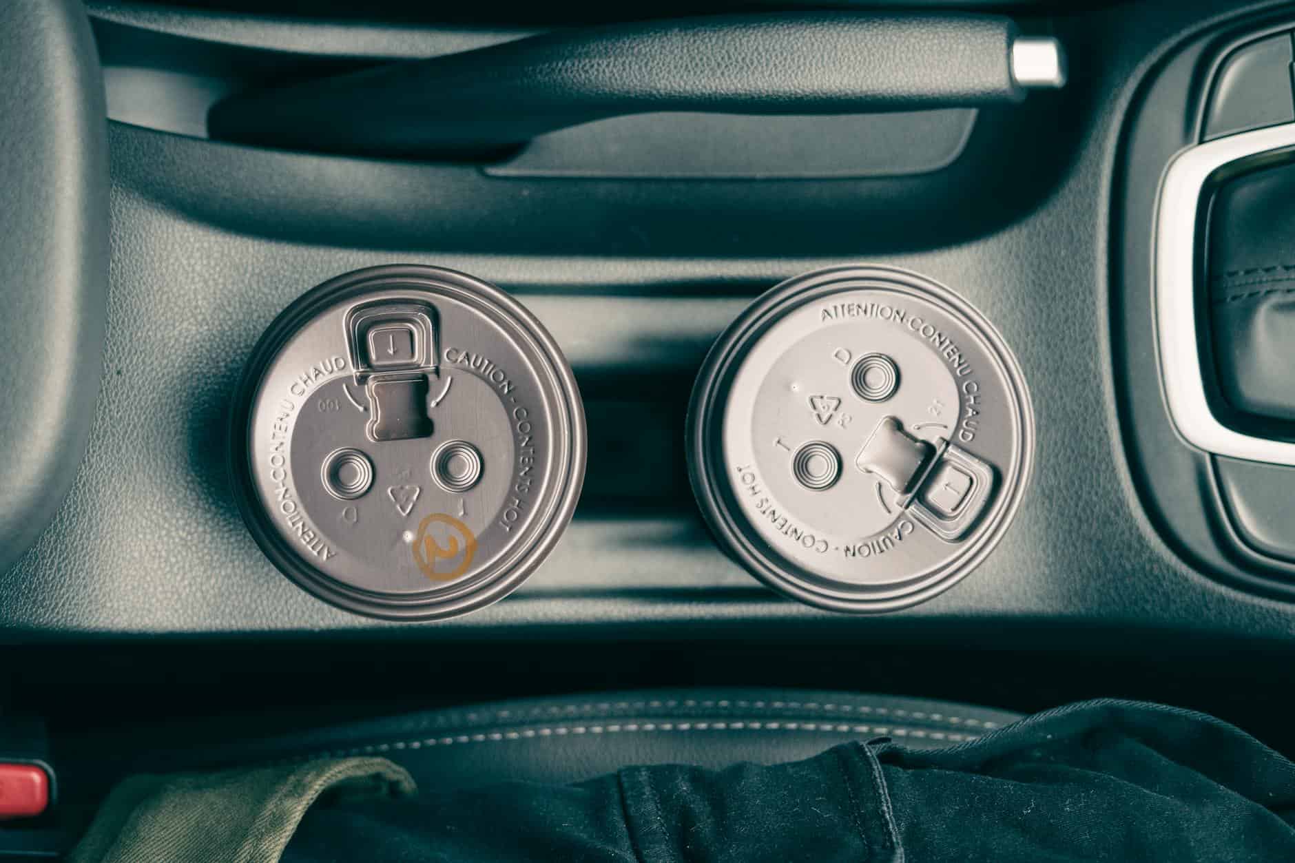 15 Road Trip Car Organizers for Traveling With Kids 5 Car interior showing two disposable coffee cups in a holder, captured from above.