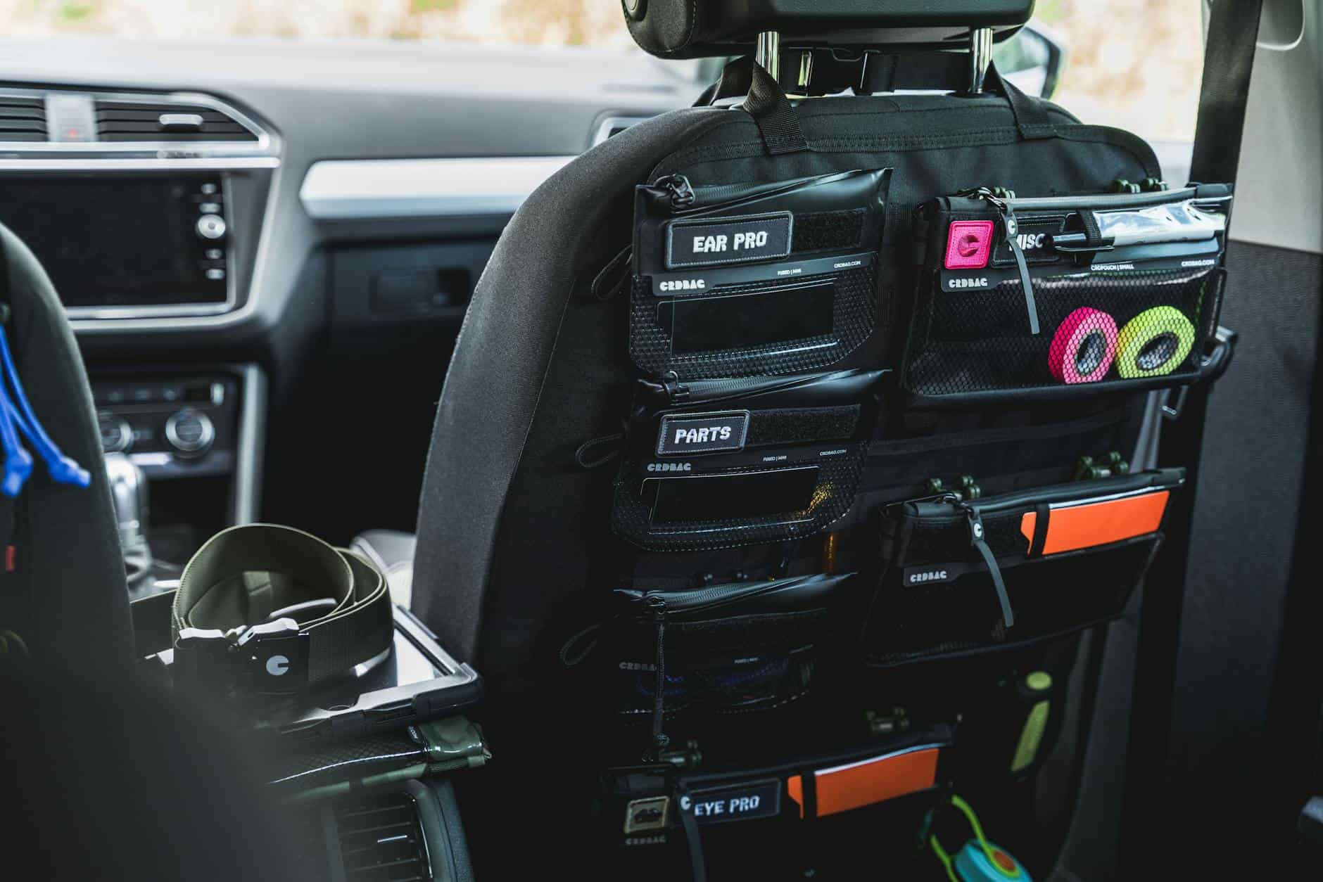 15 Road Trip Car Organizers for Traveling With Kids 2 Car seat back organizer with labeled pockets for accessories and gear storage.