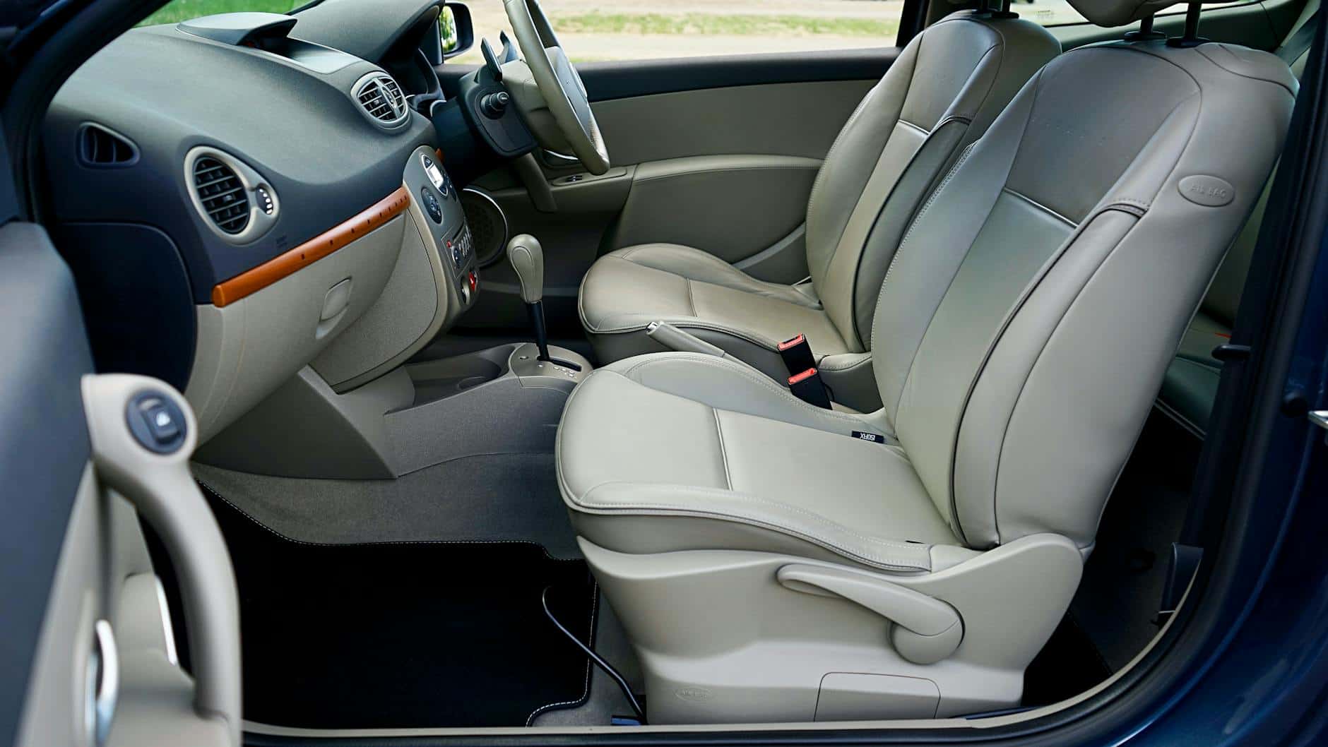 15 Road Trip Car Organizers for Traveling With Kids 9 Luxurious car interior with beige leather seats and sleek dashboard.