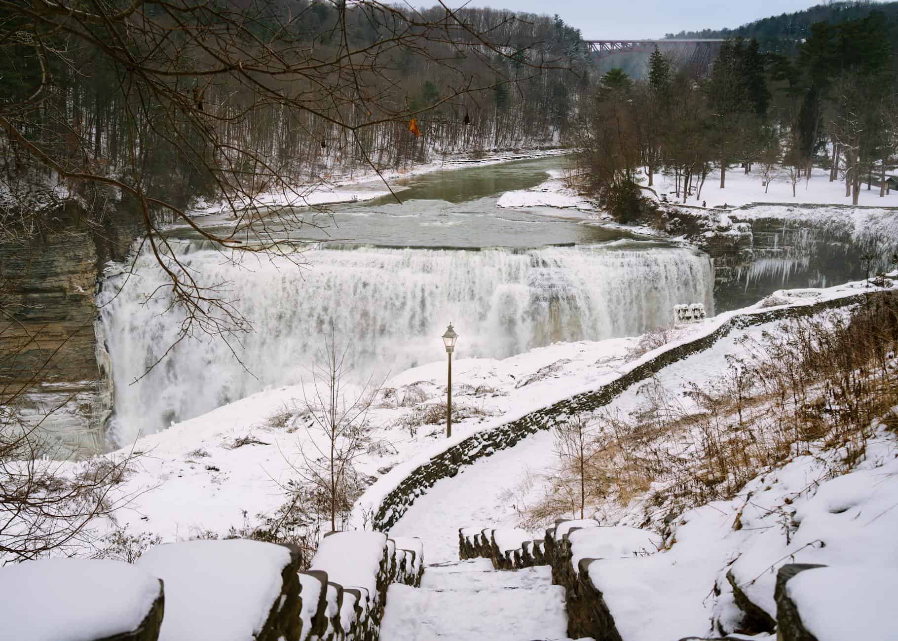 Snow-covered Letchworth State Park waterfall with scenic view from snowy steps, Castile, NY.