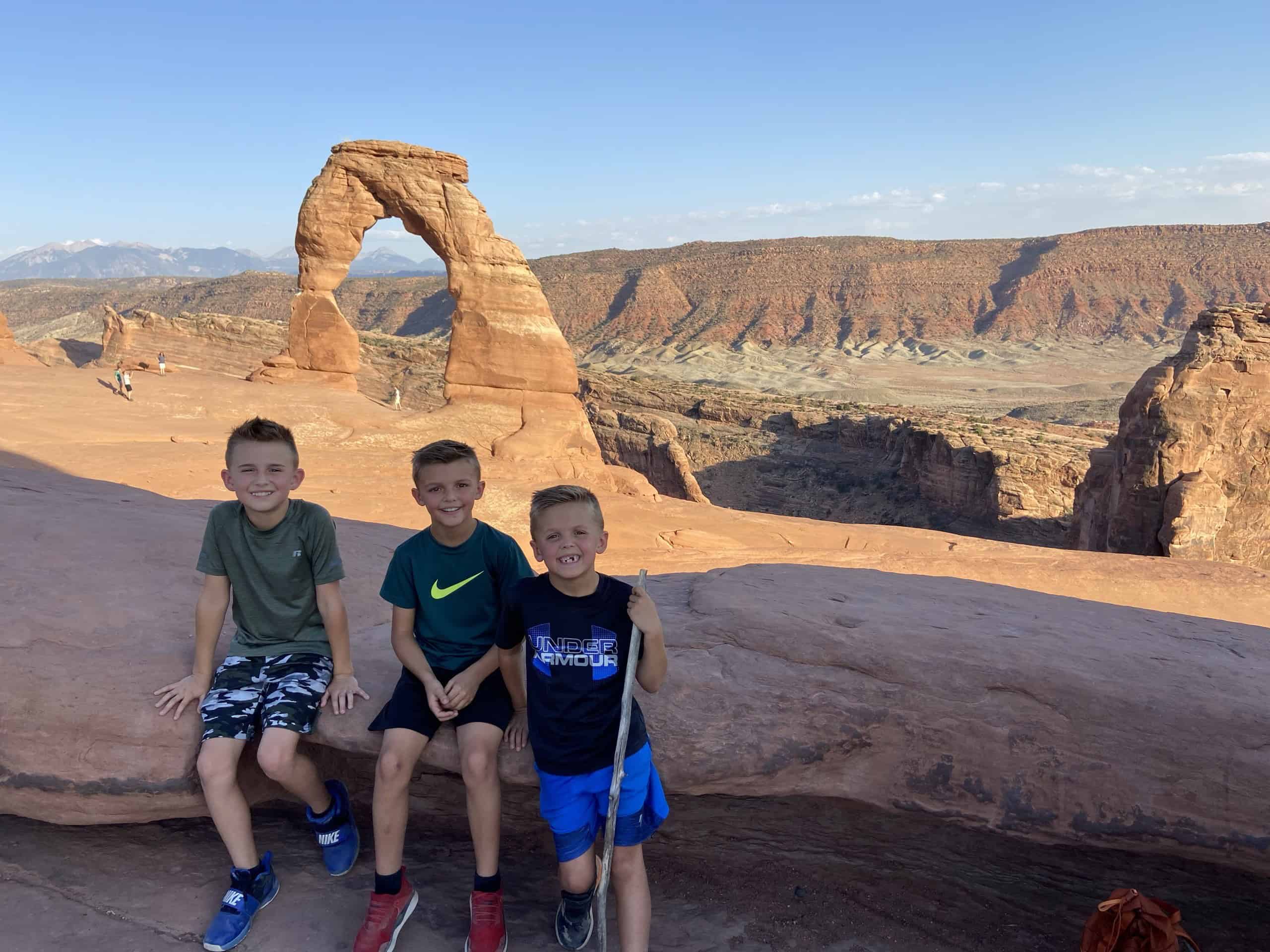We’ve Been to Arches Five Times — Here’s Why We Never Get Tired of It 6 Our family beneath Delicate Arch at sunset