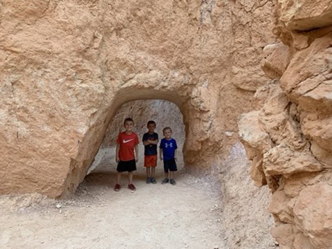 Kids standing in a rock window along the Navajo Loop Trail at Bryce Canyon