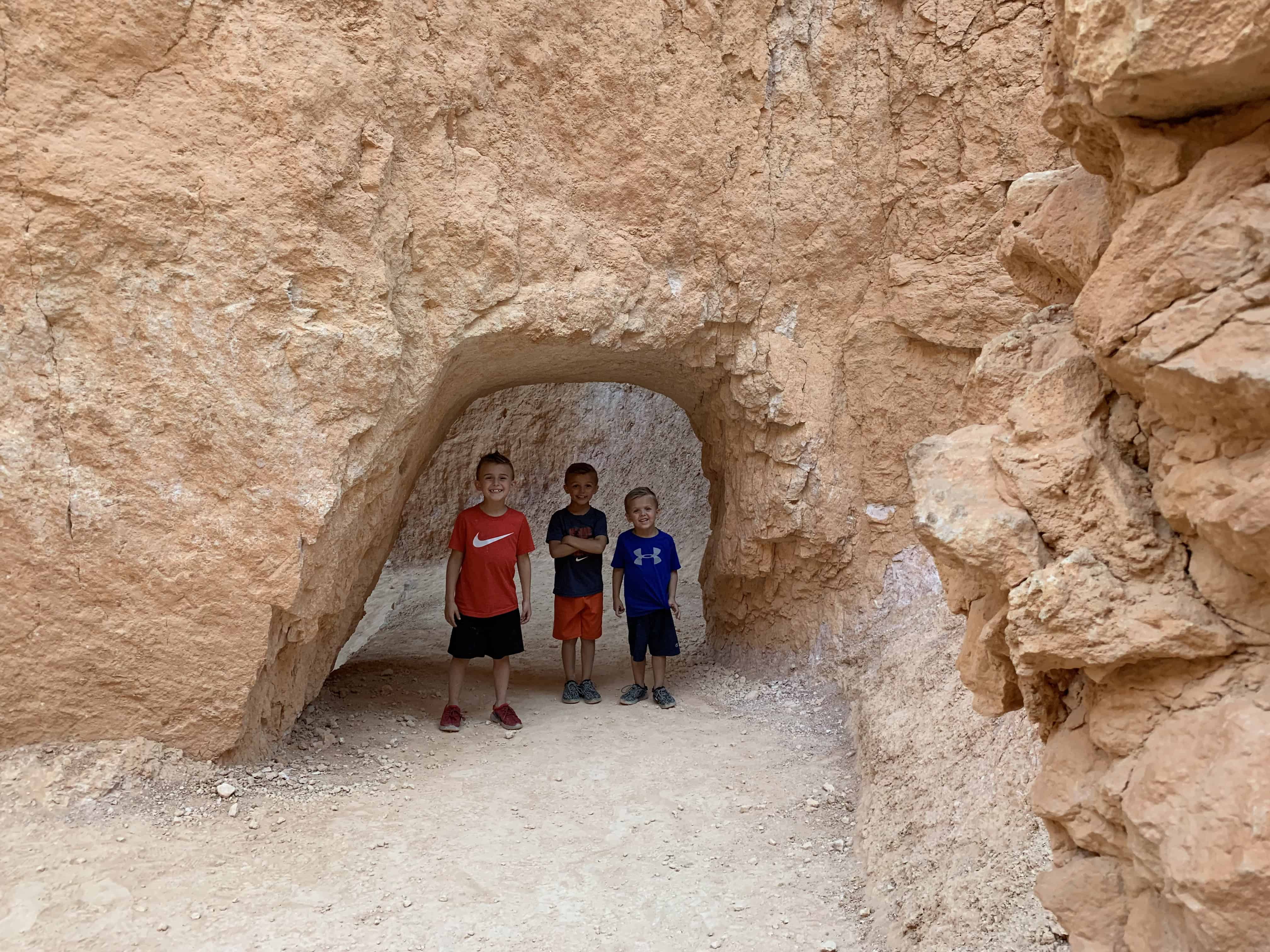 Bryce Canyon After Dark: The Most Underrated Mighty 5 Stop 5 Kids standing in a rock window along the Navajo Loop Trail at Bryce Canyon