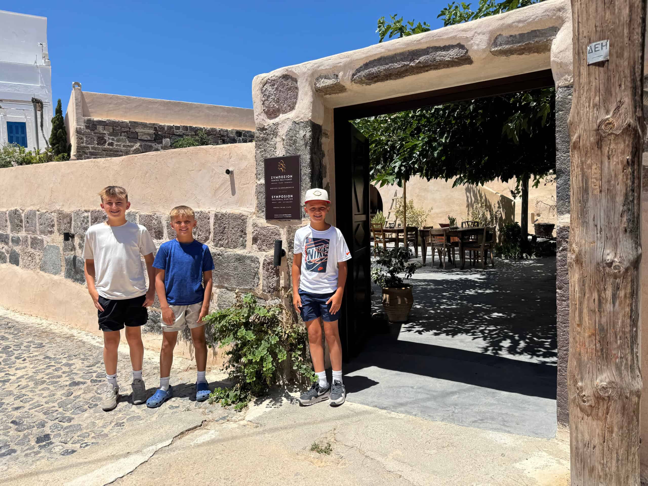 Three boys standing in front of a stone archway